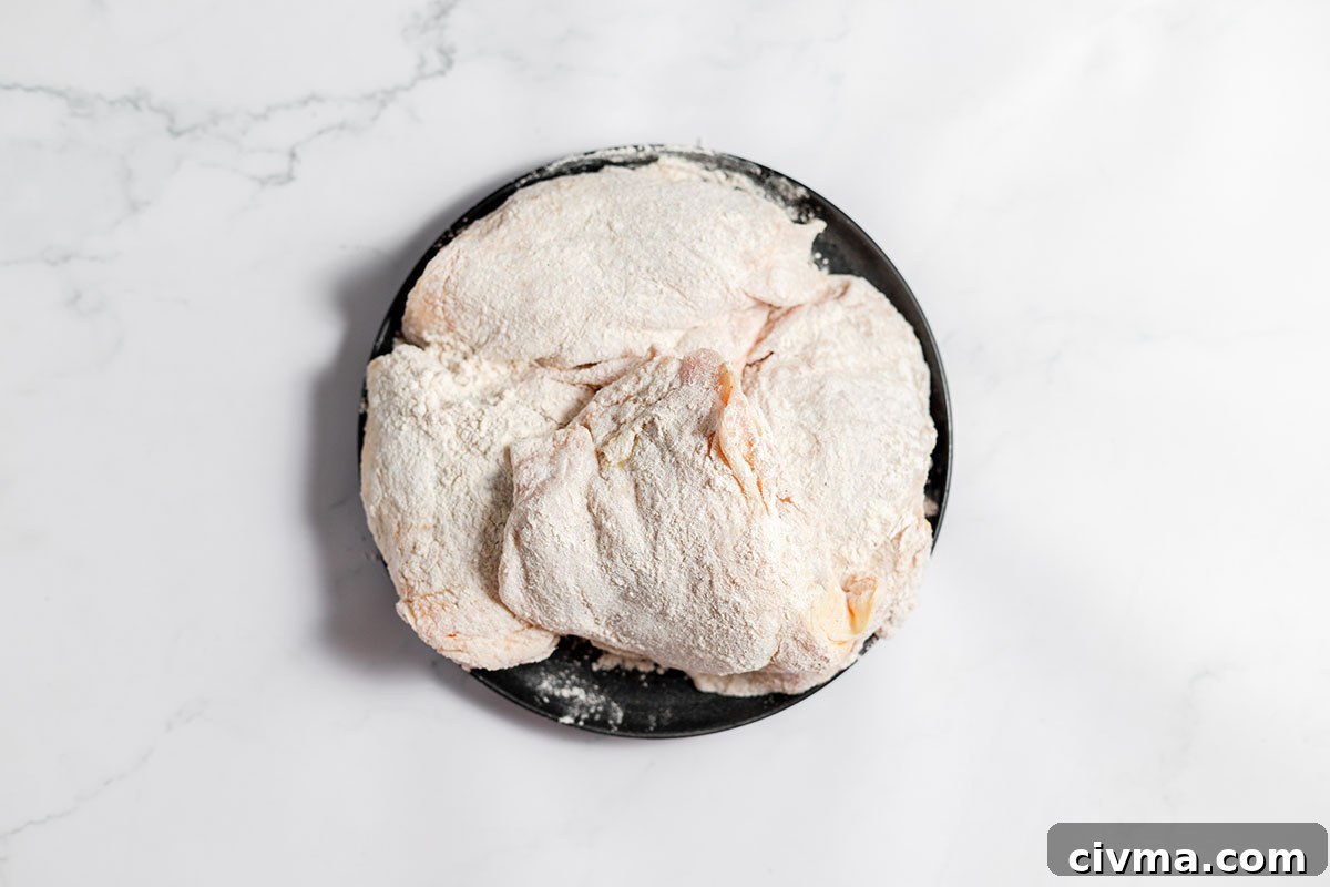 A plate with chicken coated with flour mixture.
