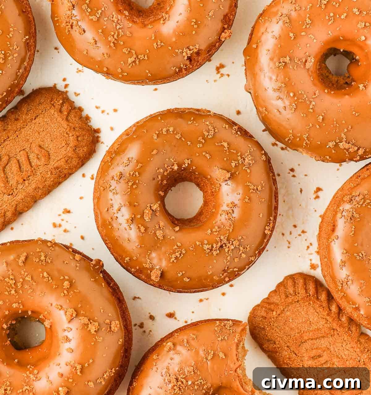 Biscoff Cookie Butter Donuts with Creamy Glaze 6 Donuts seen from above on an orange surface.