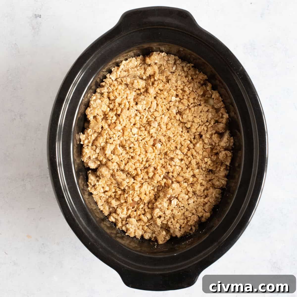Apple crumble in slow cooker basin.