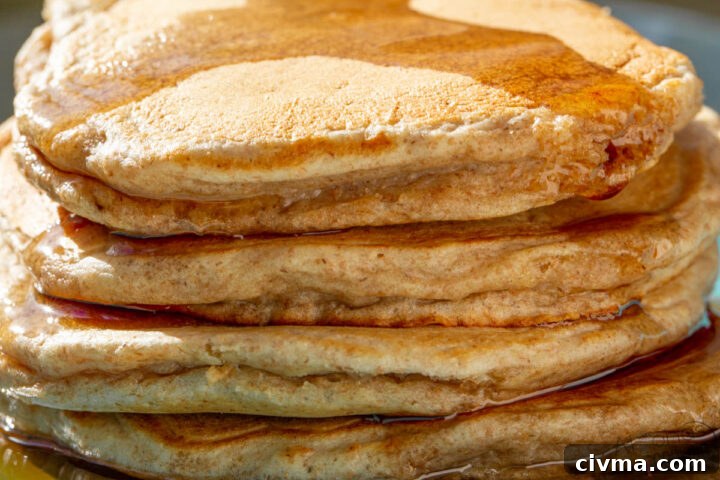 stack of whole wheat pancakes with maple syrup