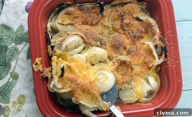 Red dish with baked onion casserole being scooped out.