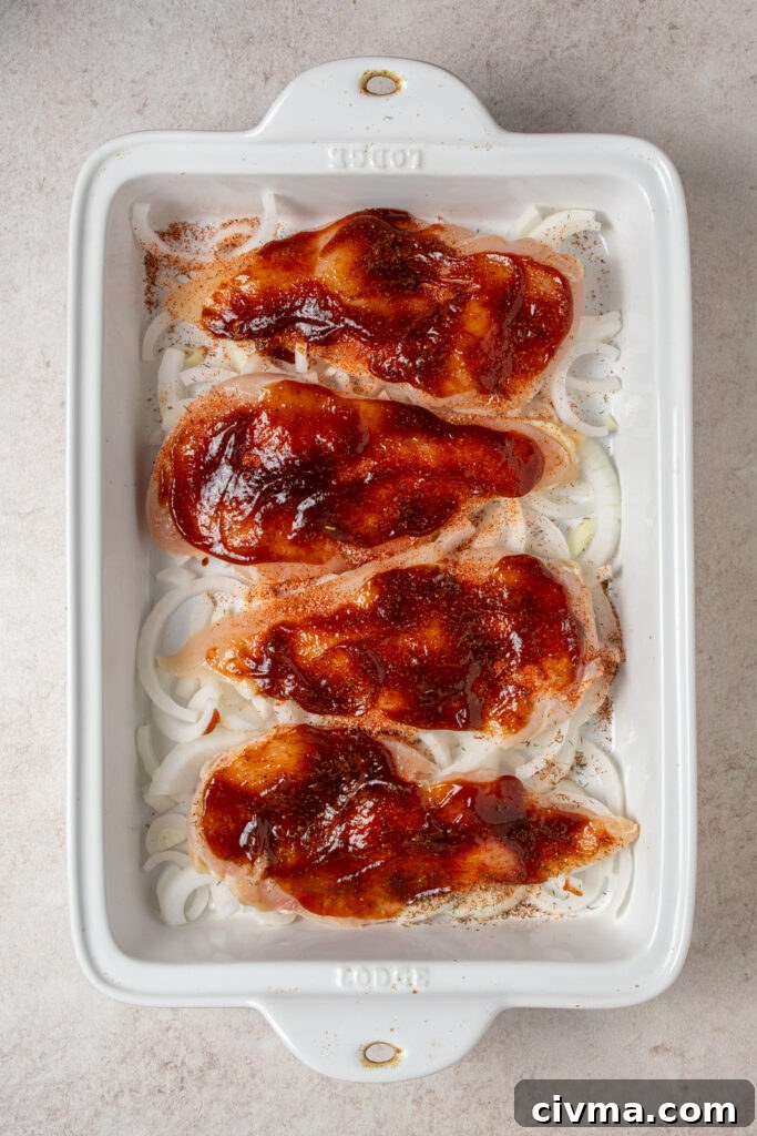 Adding barbecue sauce to chicken breasts in a casserole dish.