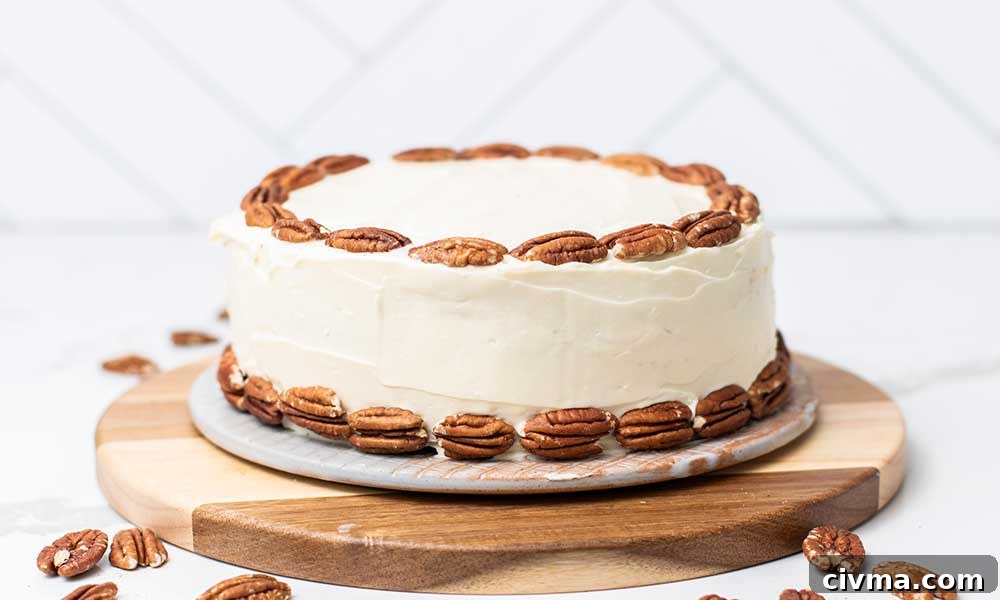 A hummingbird cake shown decorated with whole pecans.