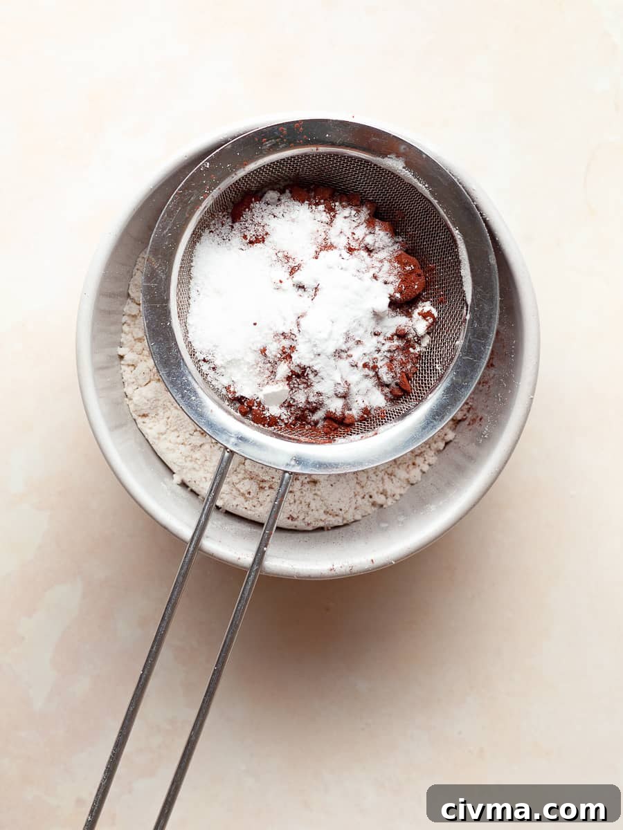 Gluten Free Air Fryer Chocolate Cake Recipe 5 a small bowl with a sifter sitting on top of it with the dry ingredients needed to make a gluten free air fryer chocolate cake