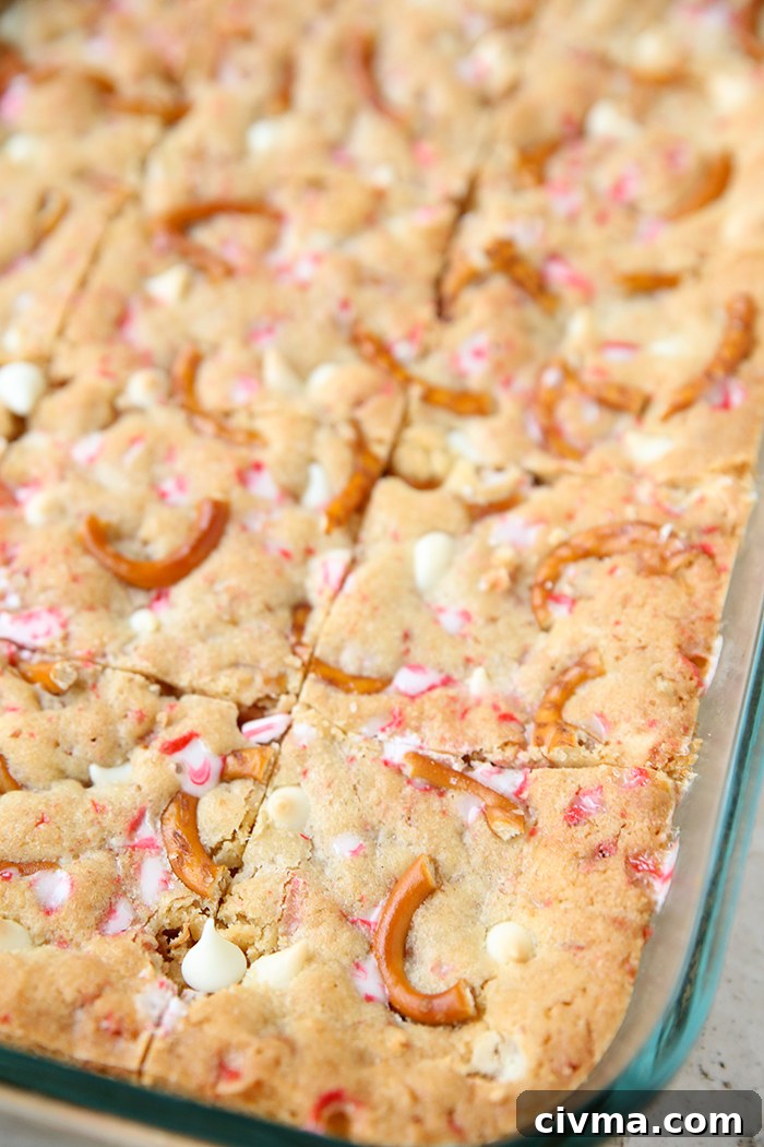 White Chocolate Peppermint Pretzel Cookie Bars 5 A partial picture of a glass 9x13 dish with cut white chocolate peppermint pretzel cookie bars.
