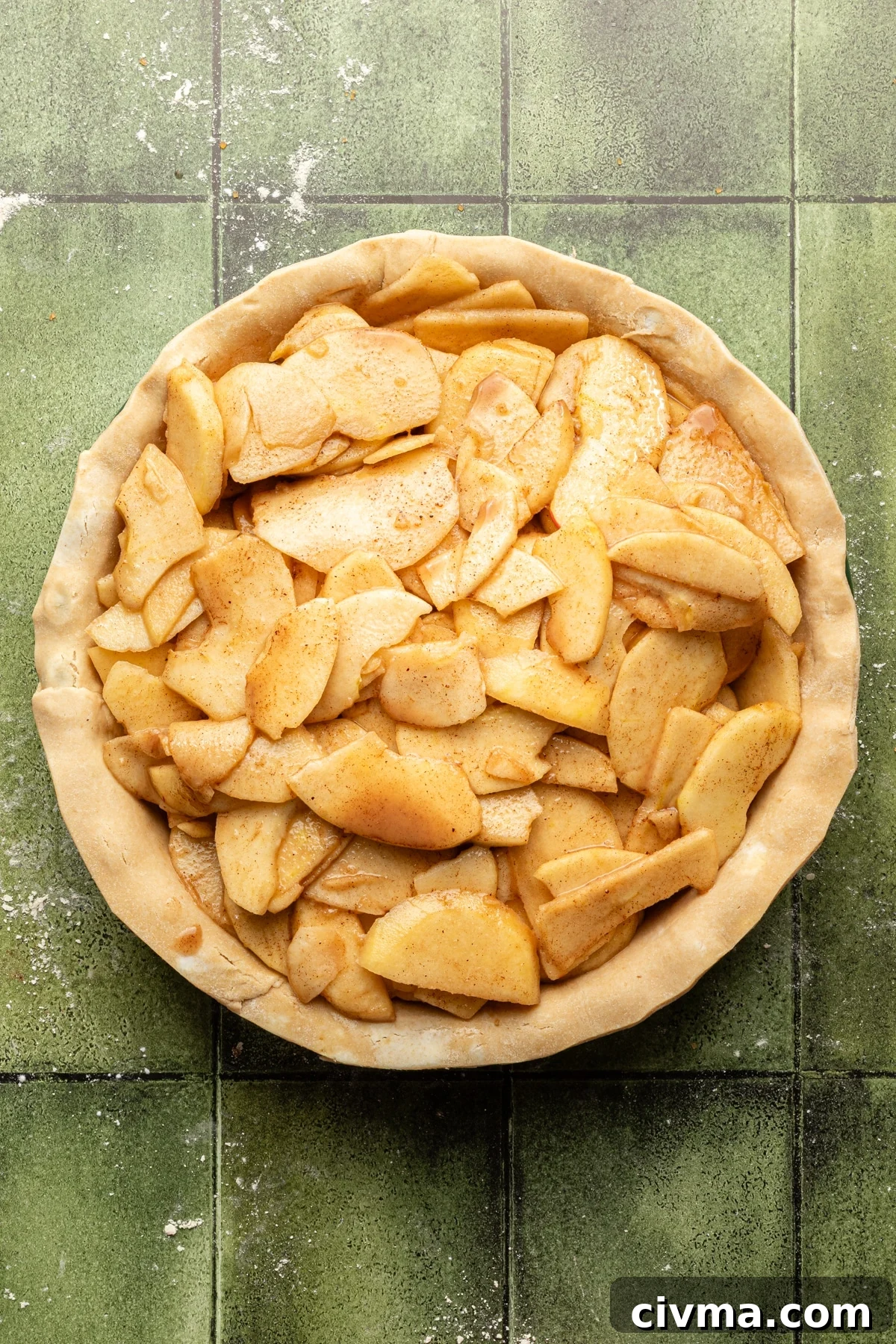 Apple Pie Recipe with Less Sugar and Flaky Crust 10 Apple filling being added to apple pie.