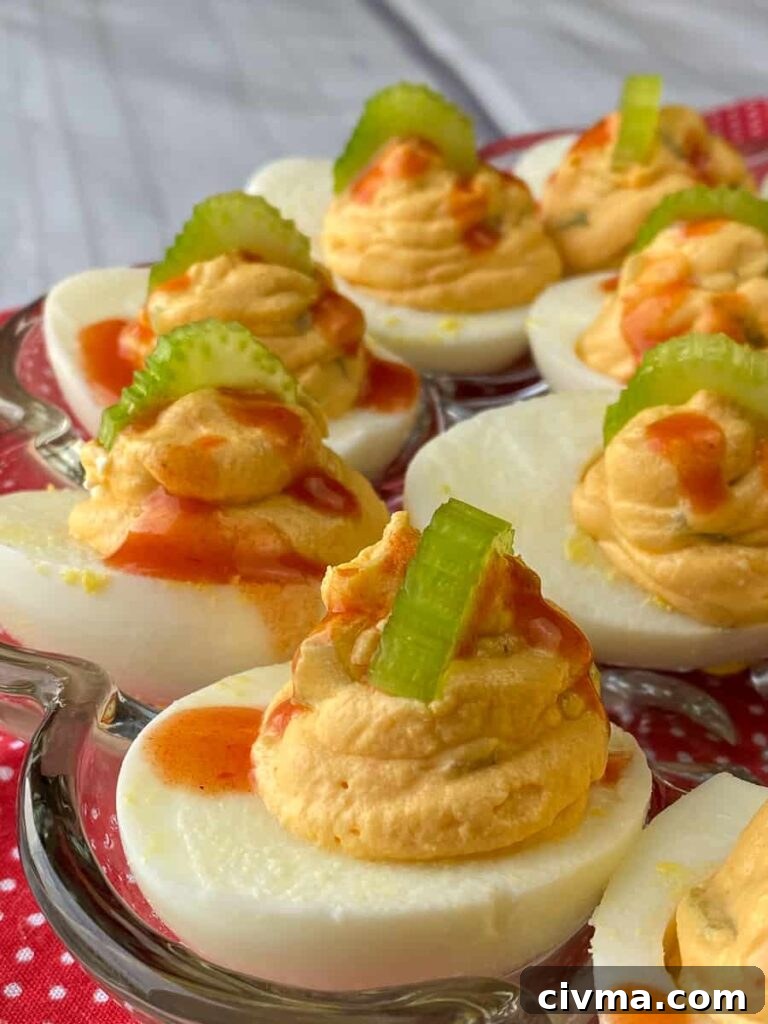 Deviled eggs drizzled with hot sauce and slices of celery