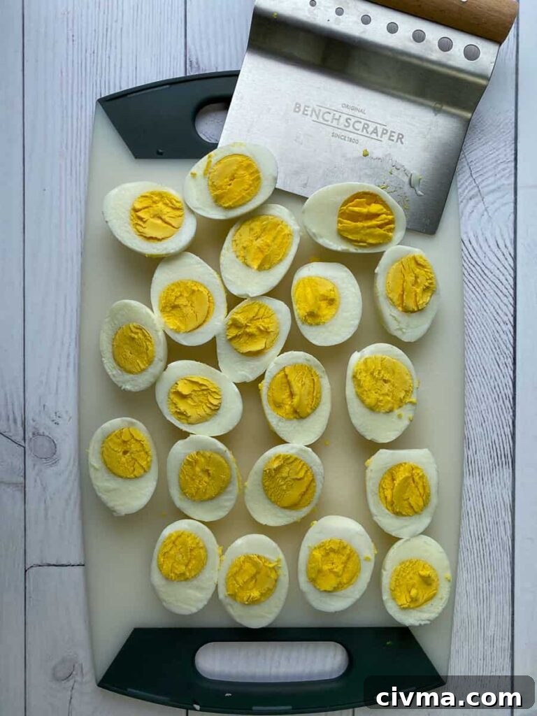 Using bench scraper to slice boiled eggs in half