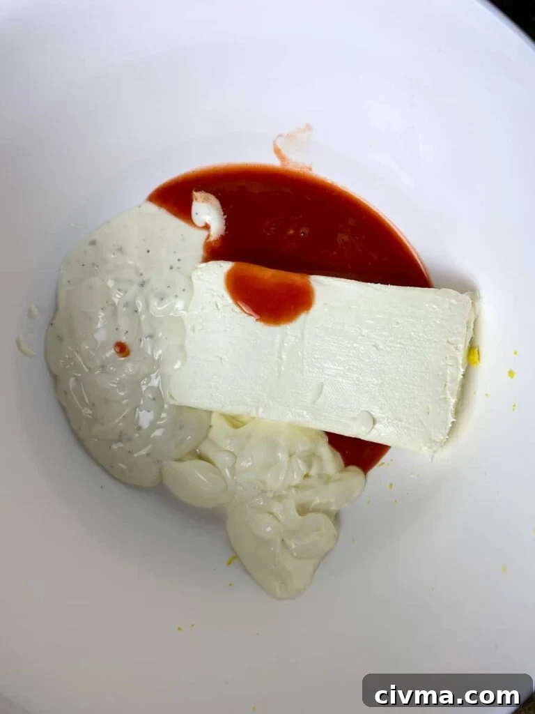 Cream cheese, ranch, mayo and hot sauce in mixing bowl