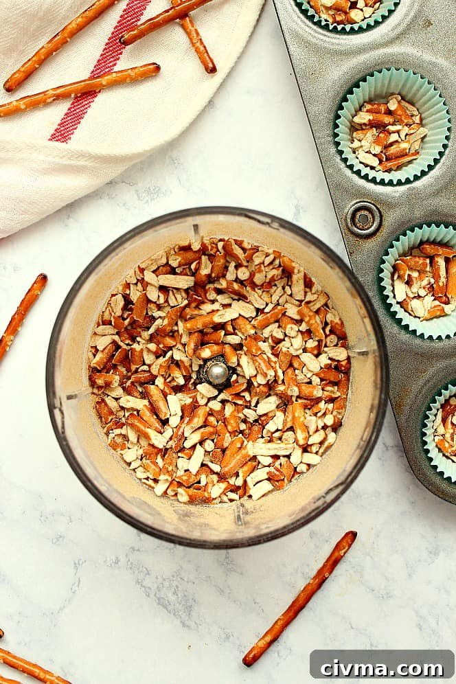 How to make caramel pretzel cups Overhead shot of pretzels crushed in mini food processor bowl and mini cupcake liners.