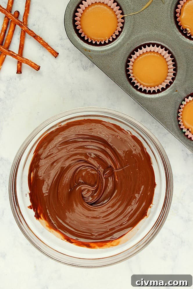 How to make chocolate pretzel caramel cups candy Overhead shot of melted chocolate in glass bowl.