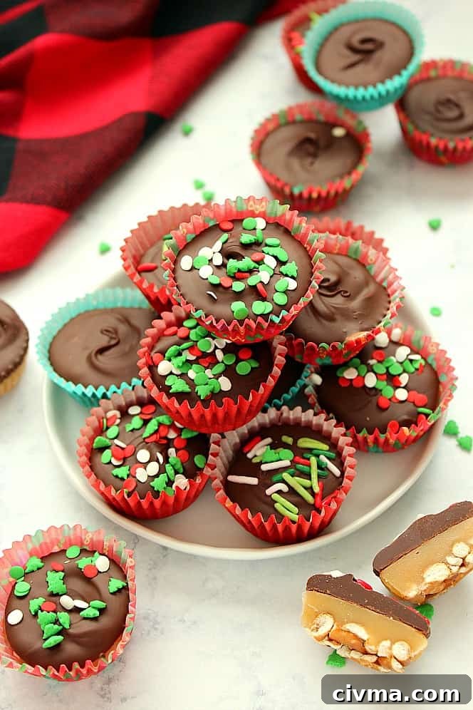 Chocolate Caramel Pretzel Cups Recipe Side shot of chocolate cups with Christmas sprinkles stacked up on white plate.