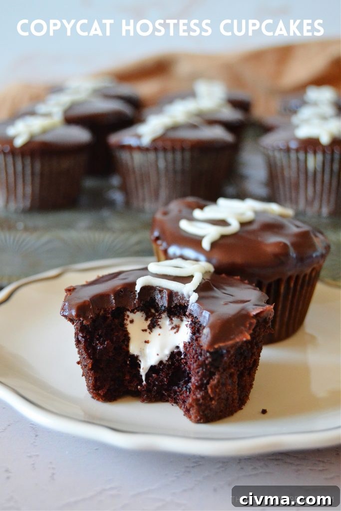 a bitten hostess copycat cupcake on a white small plate with more cupcakes in the background