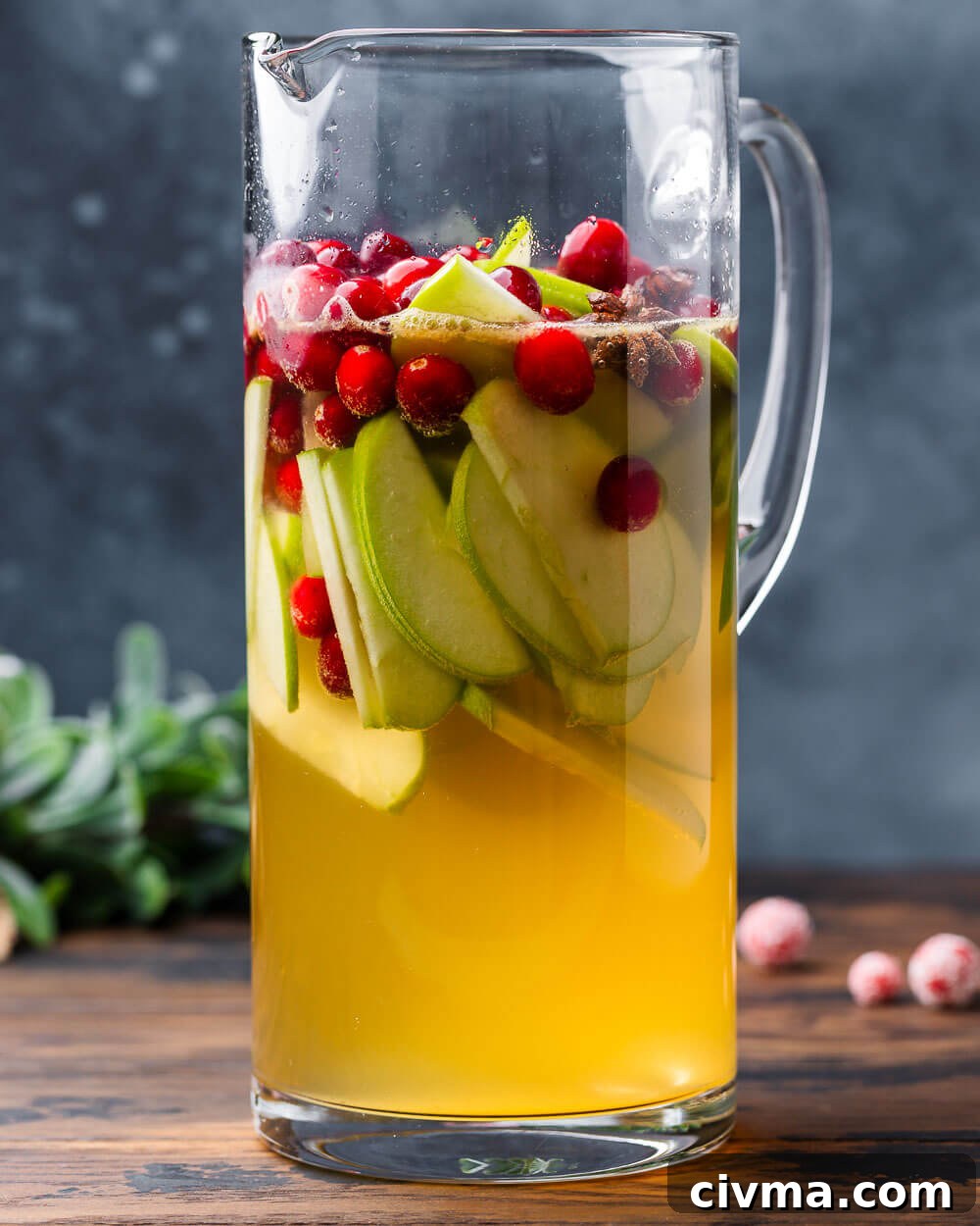 Christmas sangria in large pitcher with blue background.