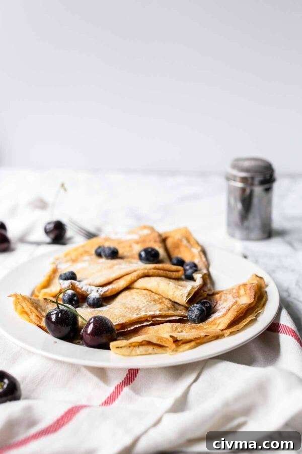 Authentic French Crepes Recipe 2 French crepes with blueberries on a white plate. are amazing. These thin pancakes are done in no time.