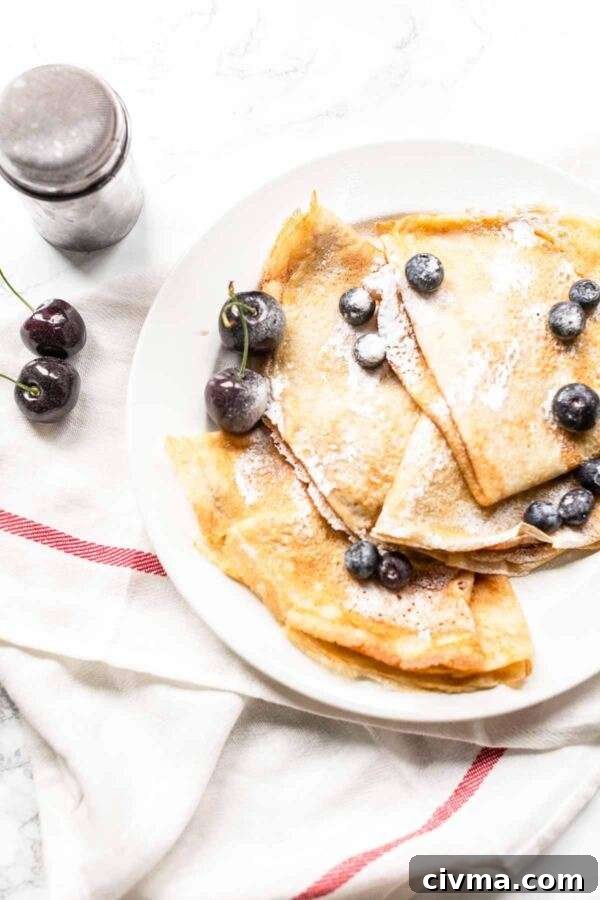 Authentic French Crepes Recipe 11 Four French crepes on a white plate.