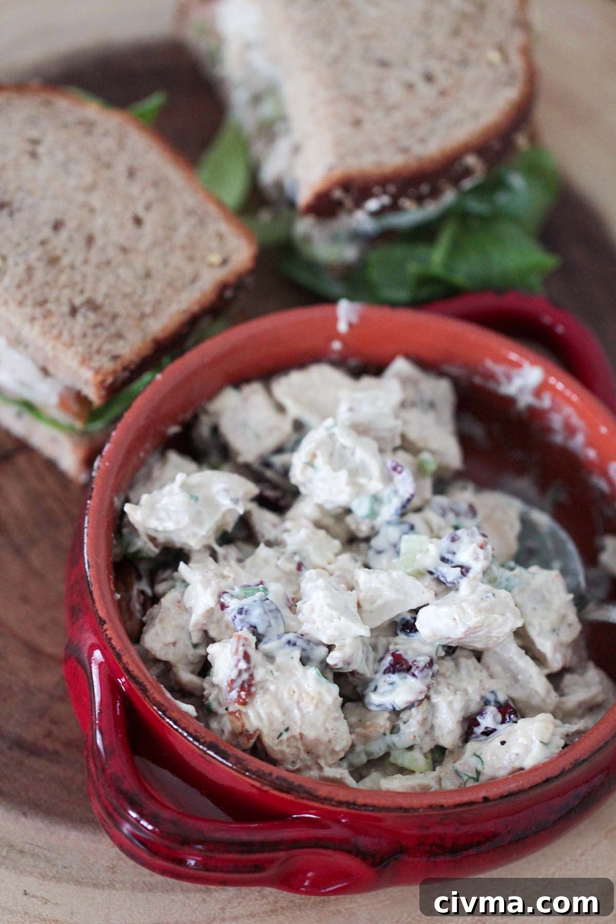chicken salad in a bowl and sandwiches in the background.