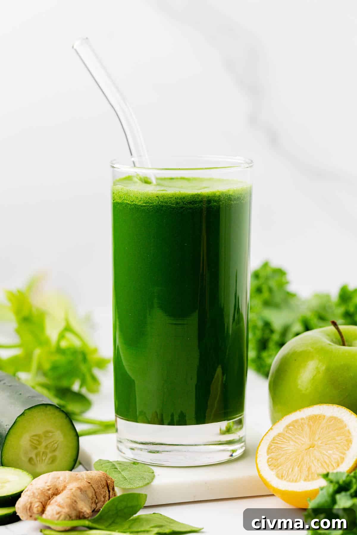 green juice in a glass with a straw