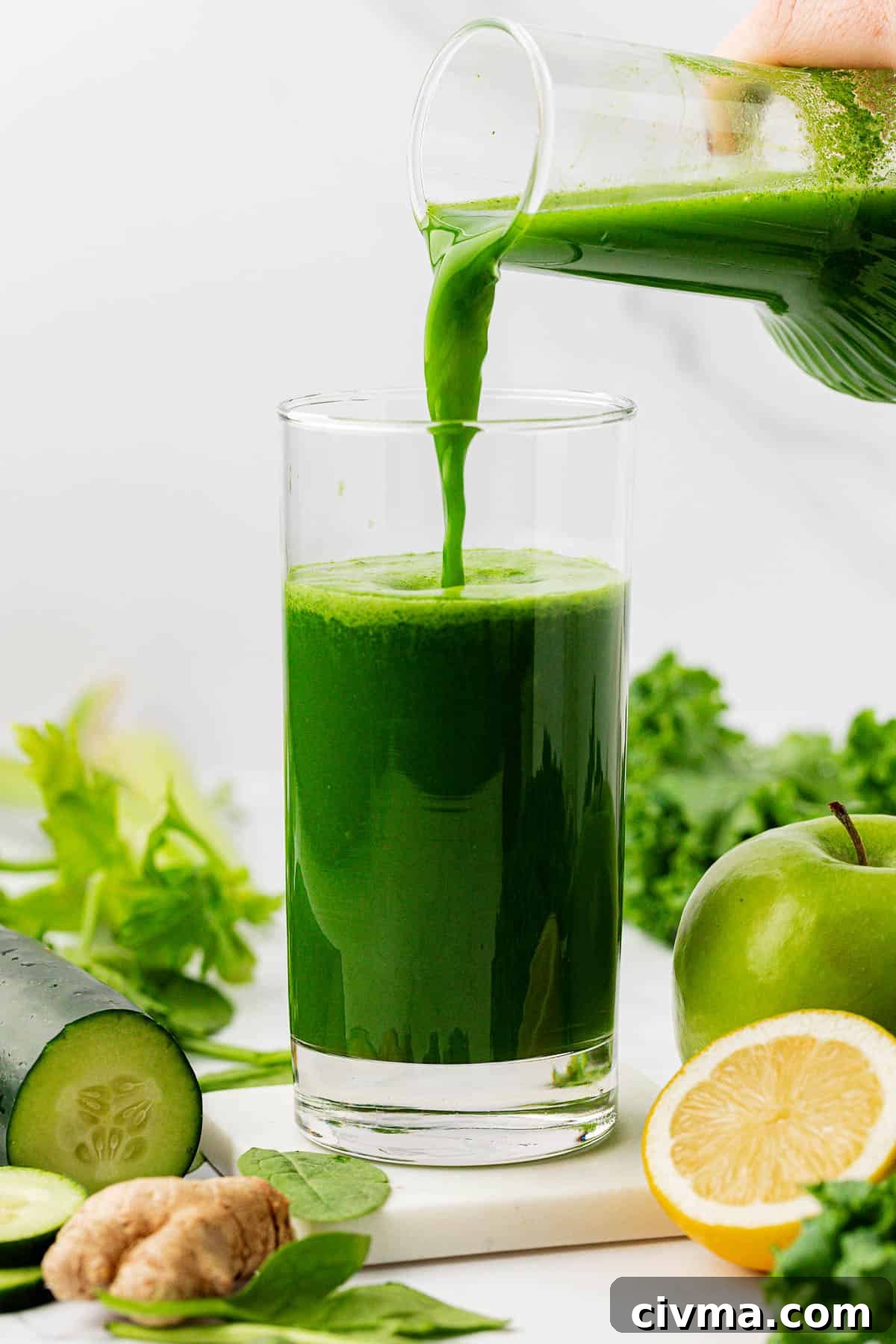 pouring green juice into a glass