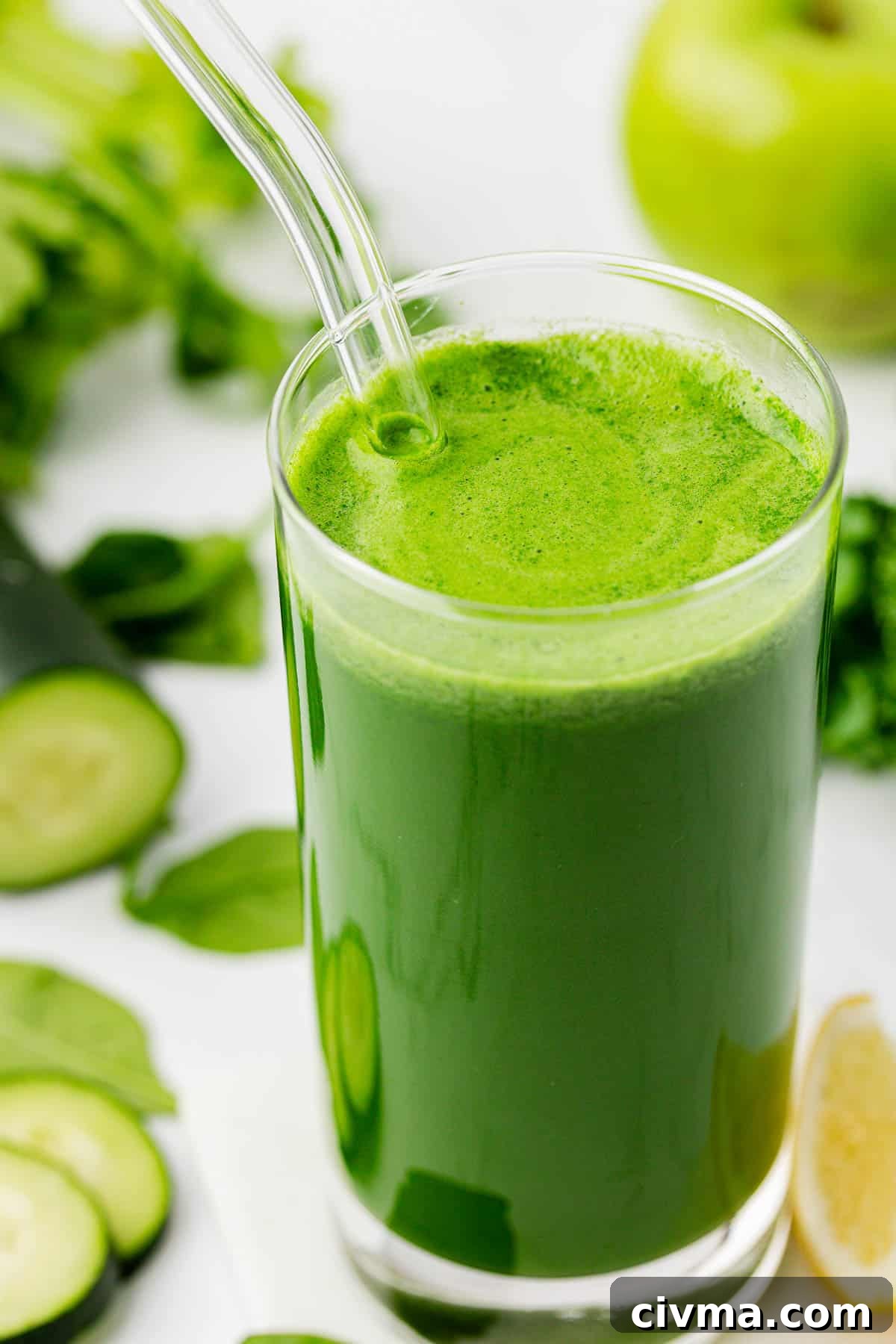 green juice in a glass with a straw