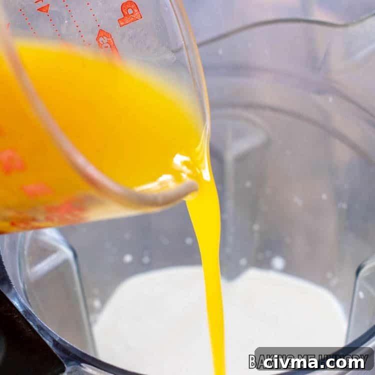 Creamy Mango Coconut Ice Cream Recipe 5 mango nectar being added to blender
