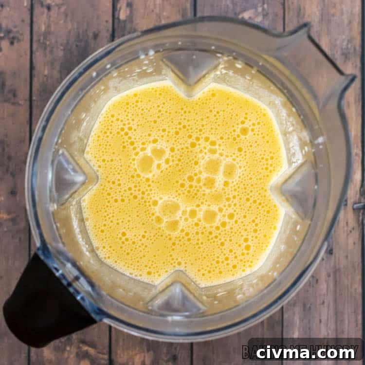 Creamy Mango Coconut Ice Cream Recipe 6 blender with orange liquid