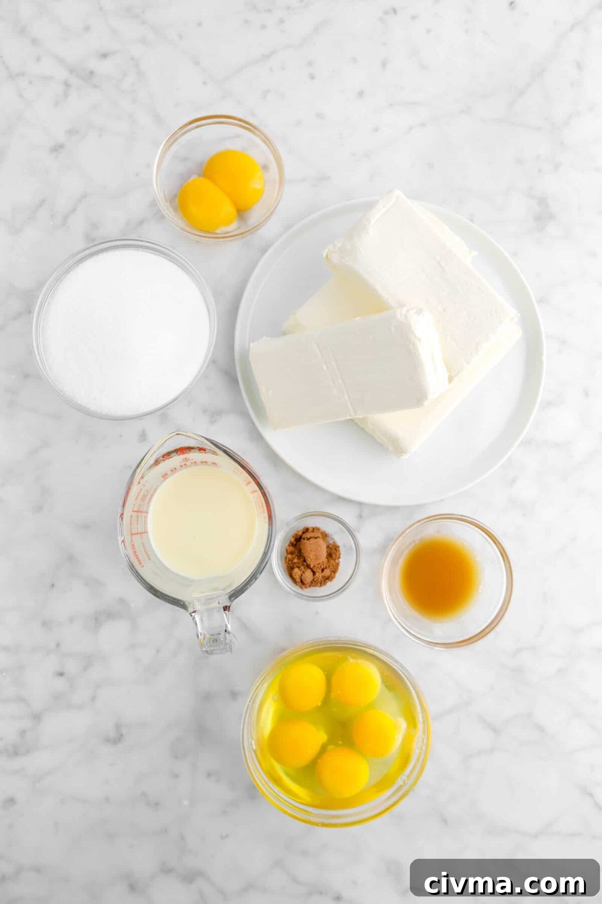 egg yolks, sugar, cream cheese, eggnog, ground nutmeg, bourbon concentrate, and eggs on marble counter