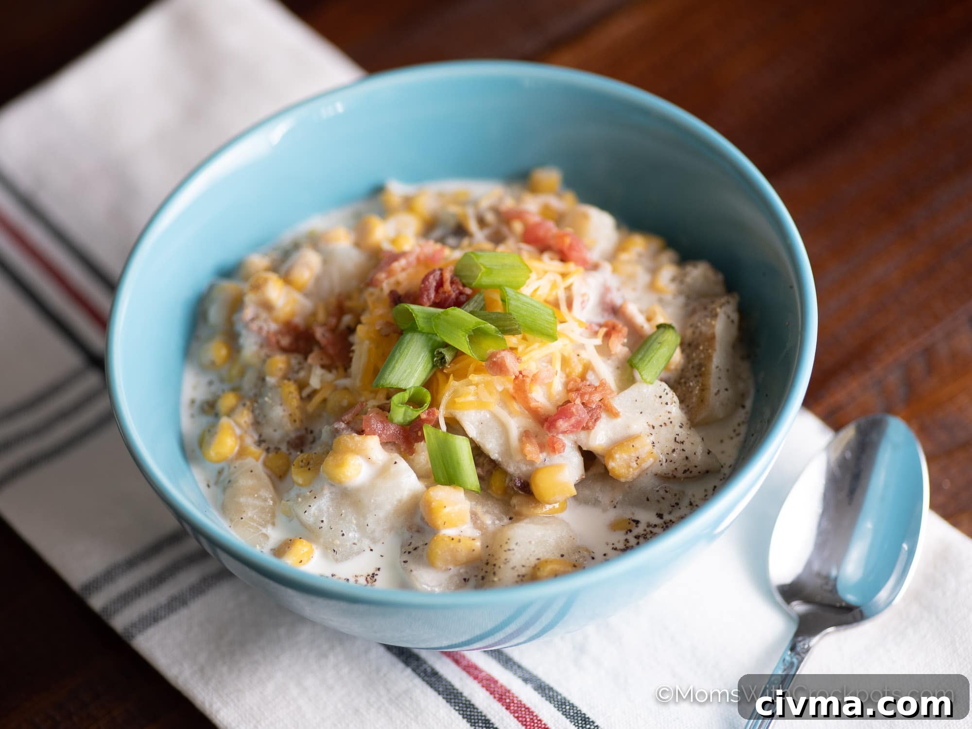 Crock Pot Bacon Corn Chowder in blue bowl with spoon