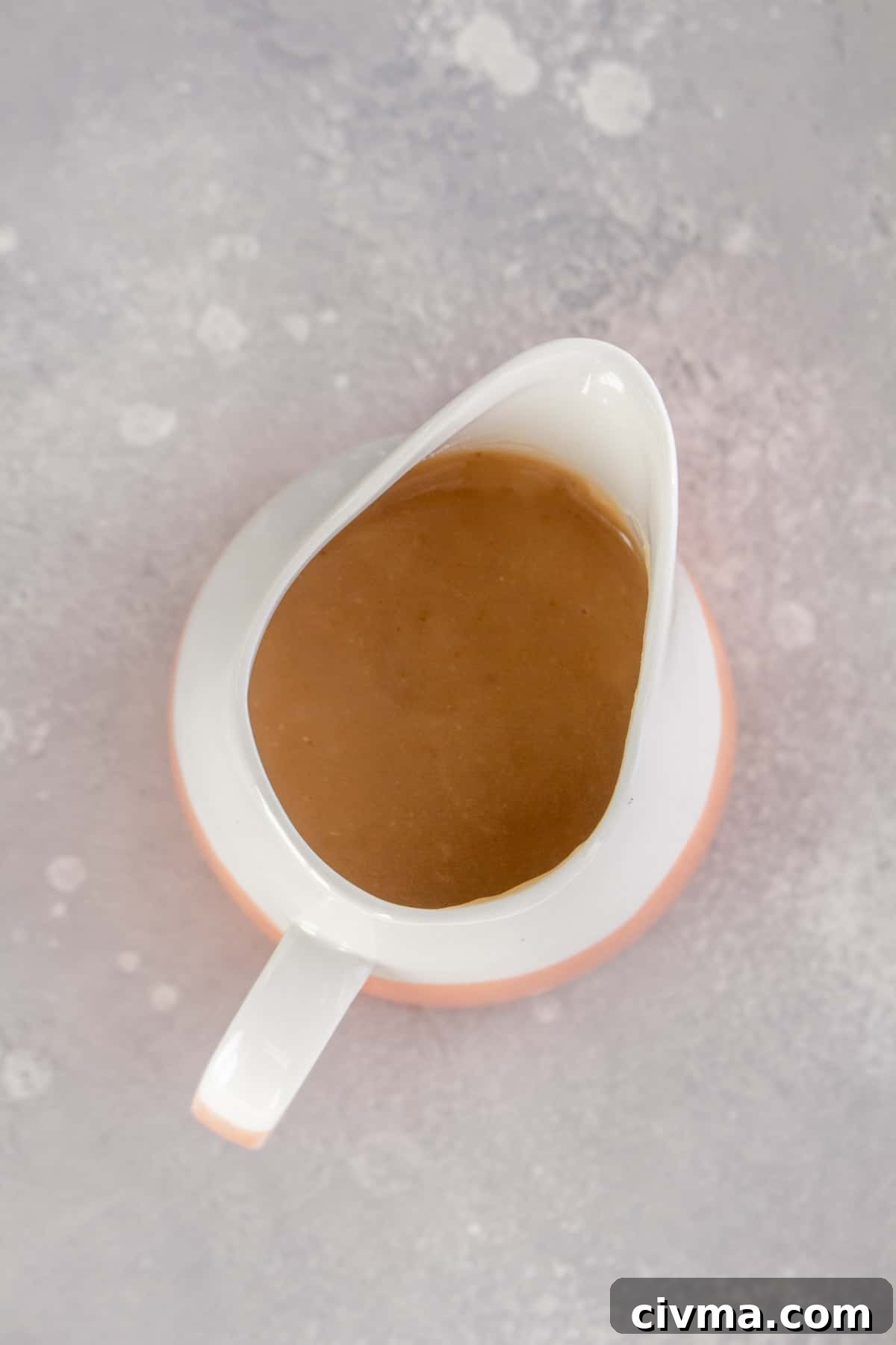 Overhead view of a gravy boat with brown gravy.