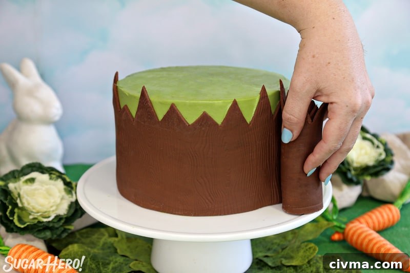 Rolling the brown fondant fence around the base of the green bunny cake