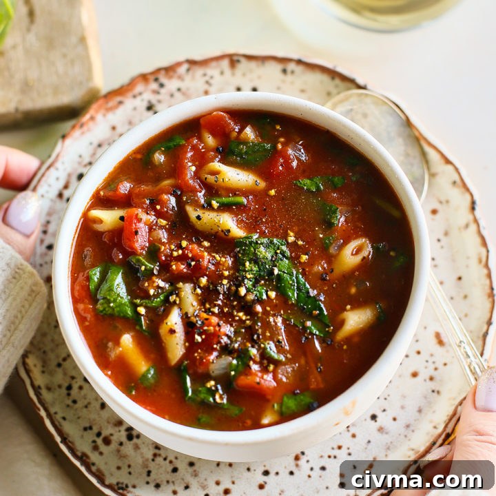 woman holding a bowl of tomato florentine soup
