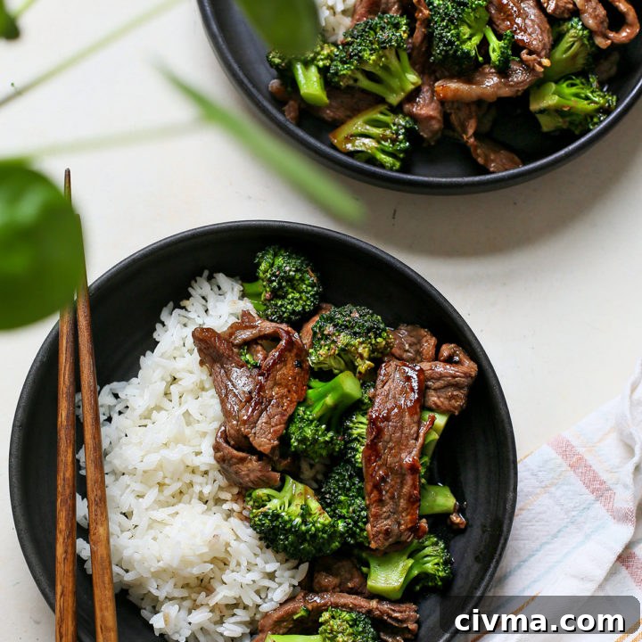 overhead photo of chinese beef and broccoli being served on two black plates