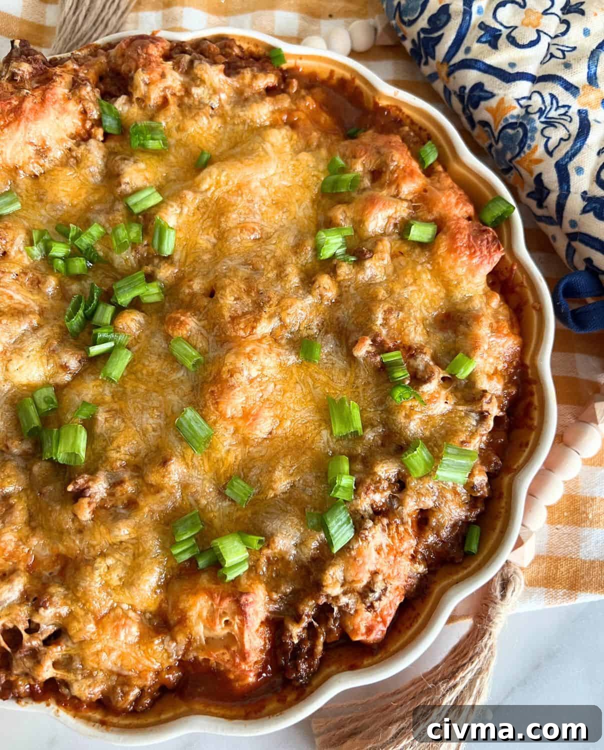 Bubble Up Enchilada Casserole 2 Bubble up enchiladas topped with green onions in a casserole dish.