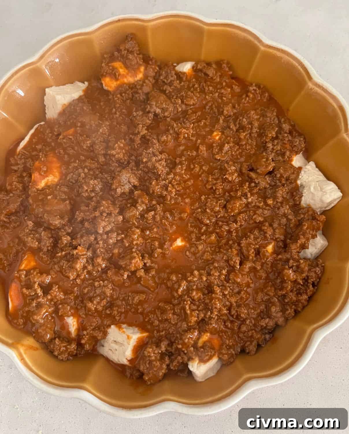 Bubble Up Enchilada Casserole 6 Ground beef mixture over layered biscuits in a casserole dish.