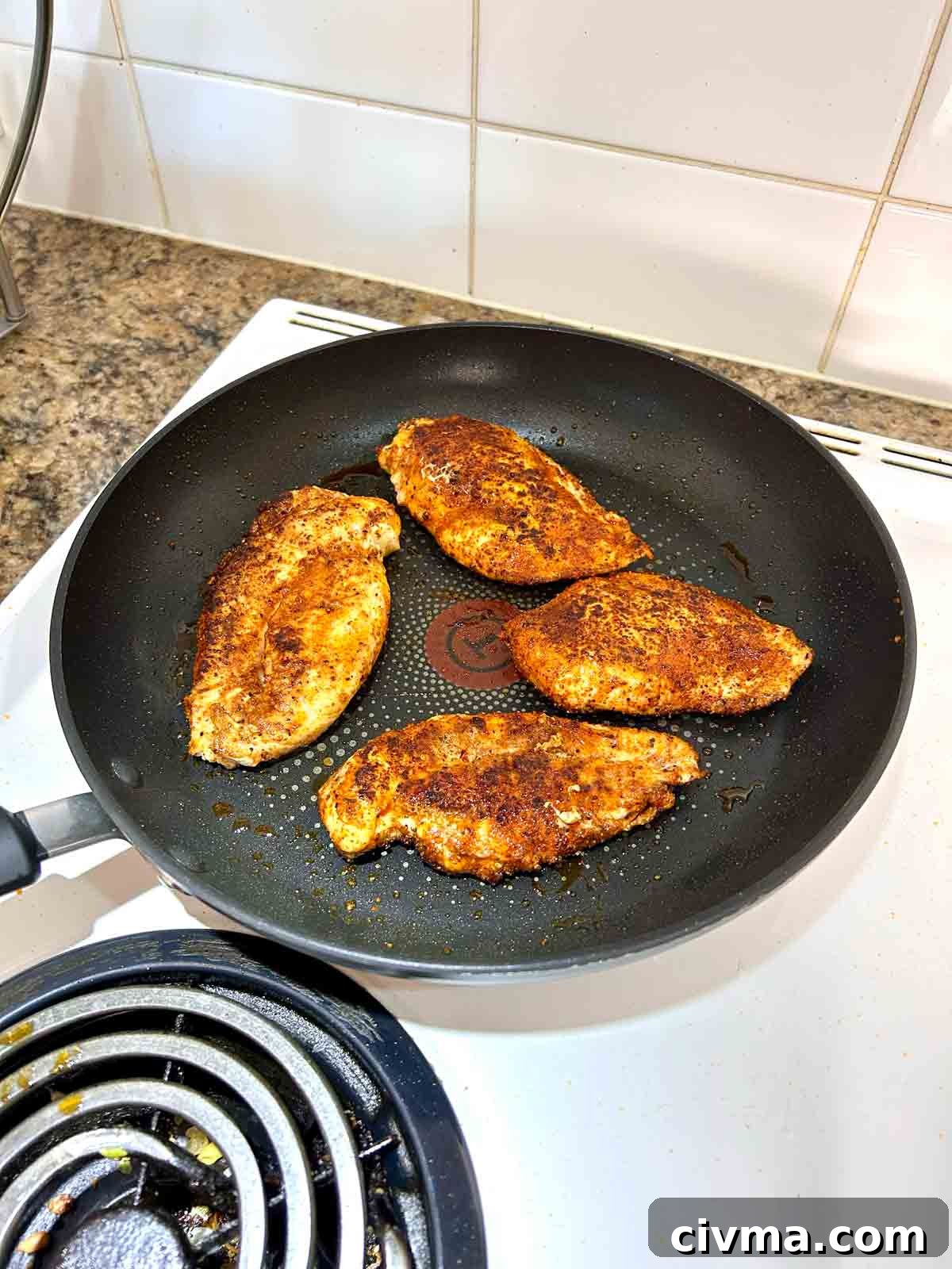 chicken being seared in pan.