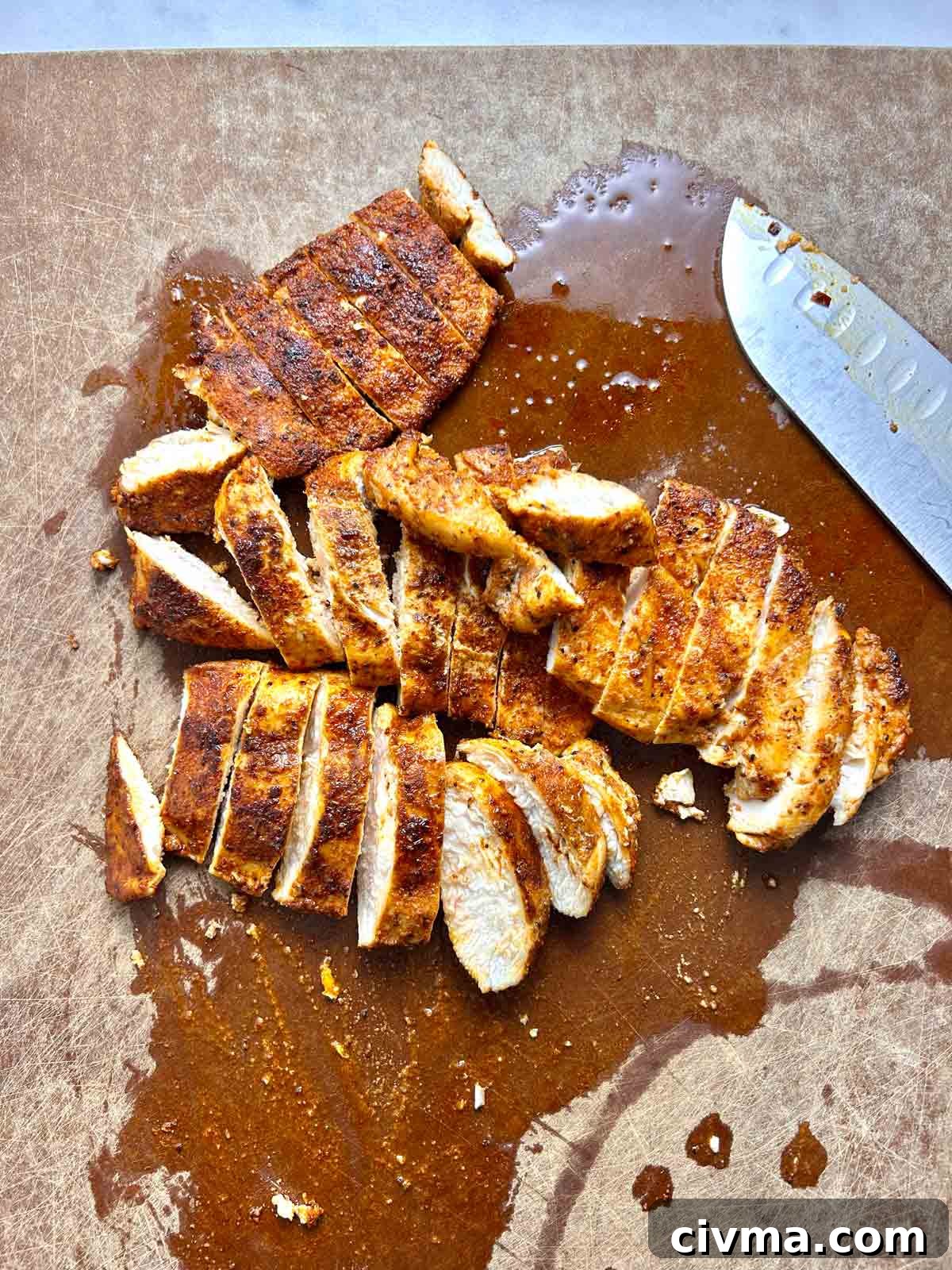 chicken cut into slices on cutting board.