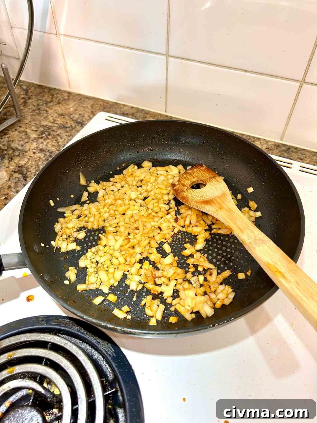 onions and garlic being sautéed in pan.