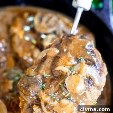 Close up of ladle scooped a salisbury steak from the pan
