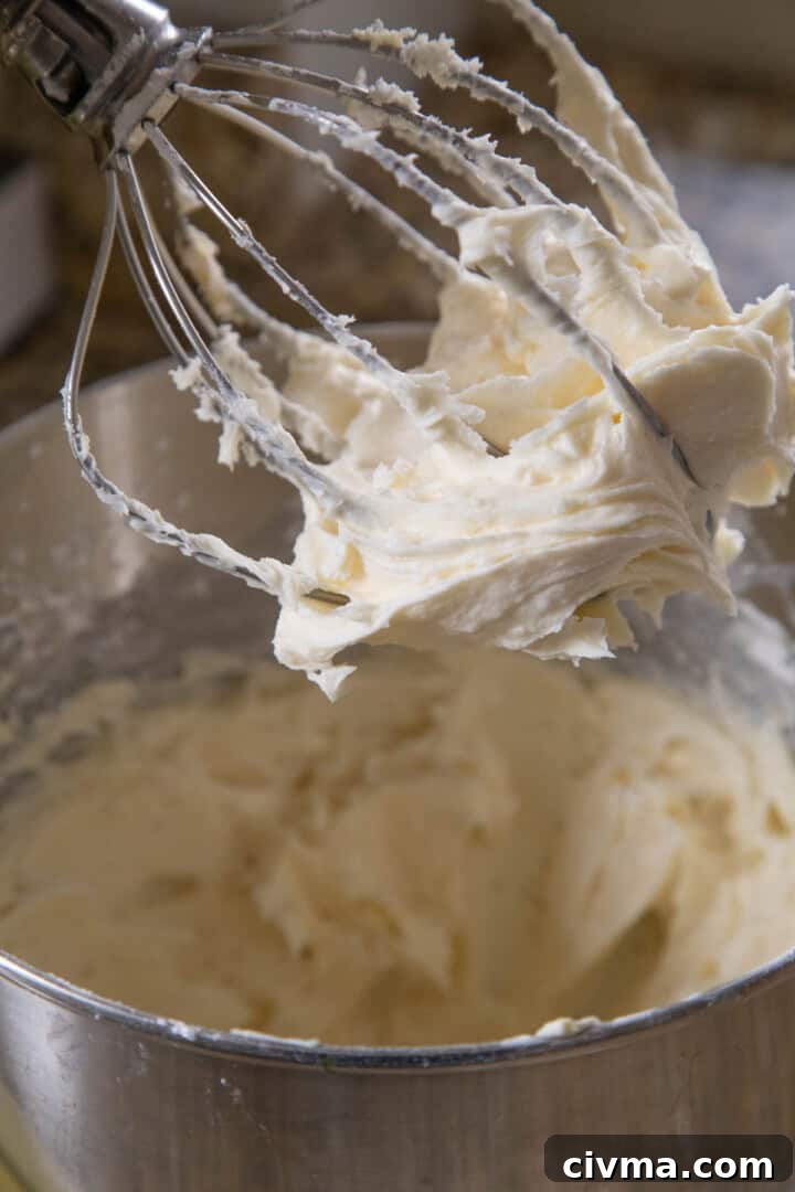 smooth cream cheese frosting on the beater of a stand mixer.