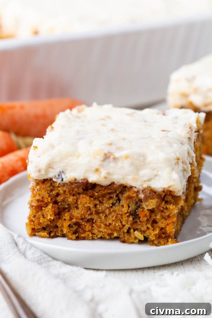 slice of carrot coconut cake with a thick layer of coconut cream cheese frosting.