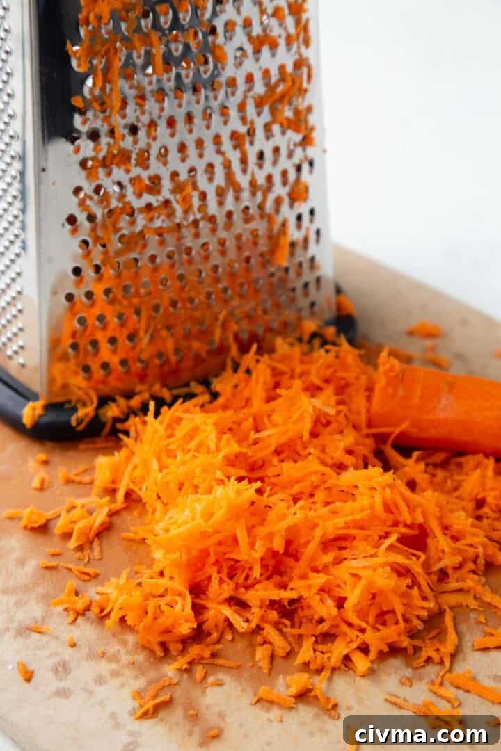 shredded carrots near a box grater.