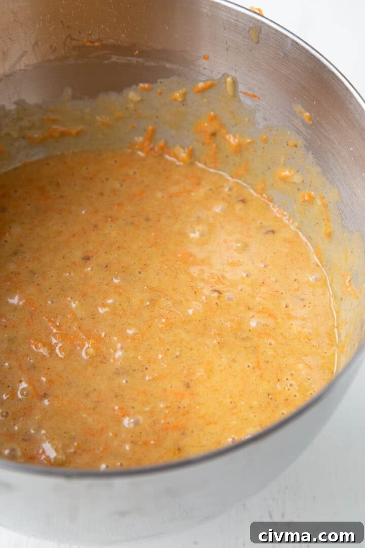 batter with carrots in a metal bowl.