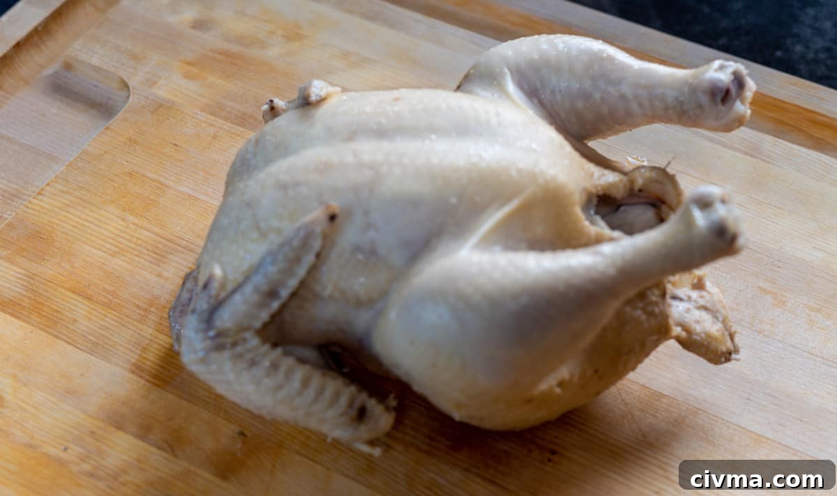 Spicy Chicken Noodle Soup Recipe 10 poached chicken on cutting board ready to shred.