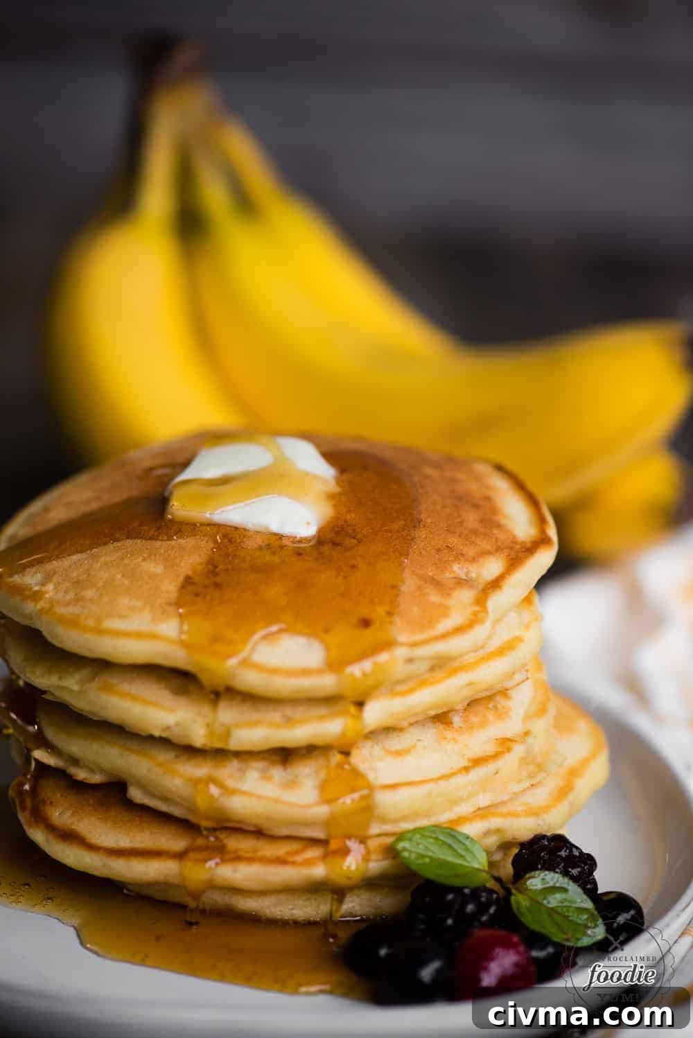 banana pancakes on plate with butter and syrup