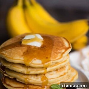 banana pancakes on plate with butter and syrup