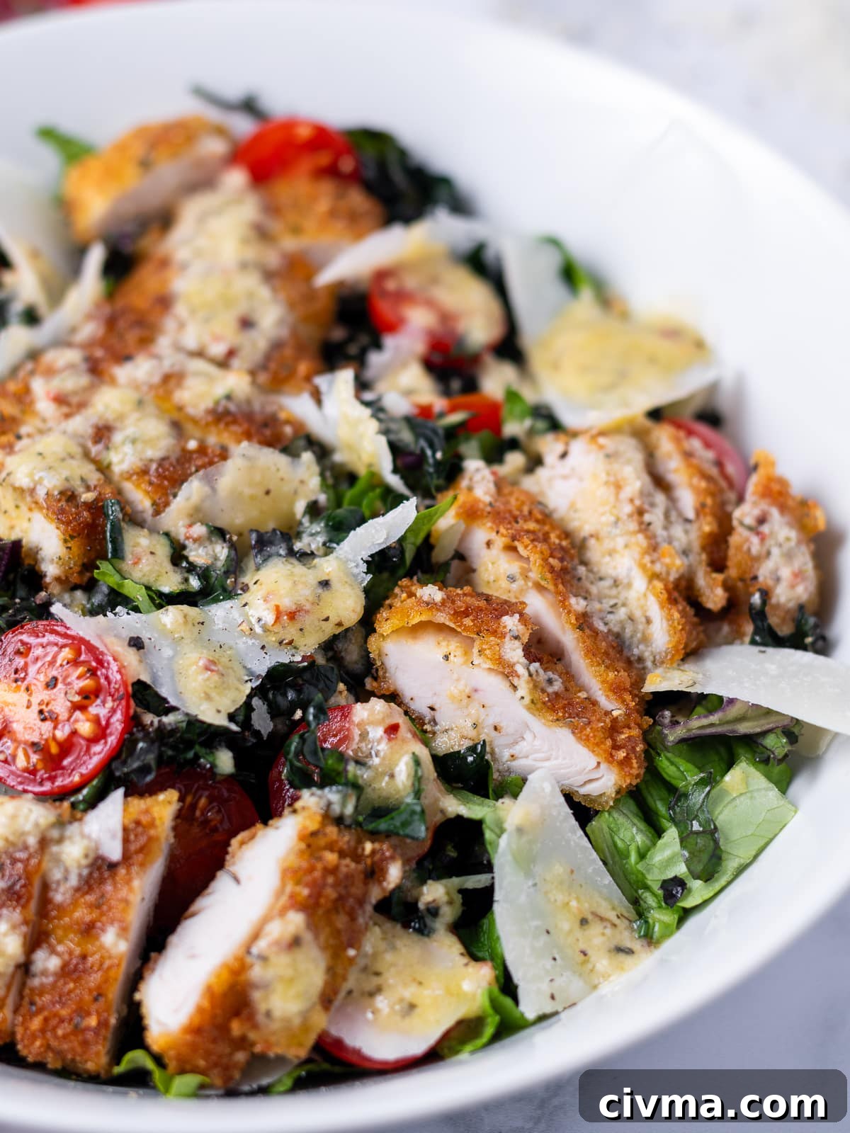 close up look at the crispy chicken and white meat center in a bowl of chicken tender salad