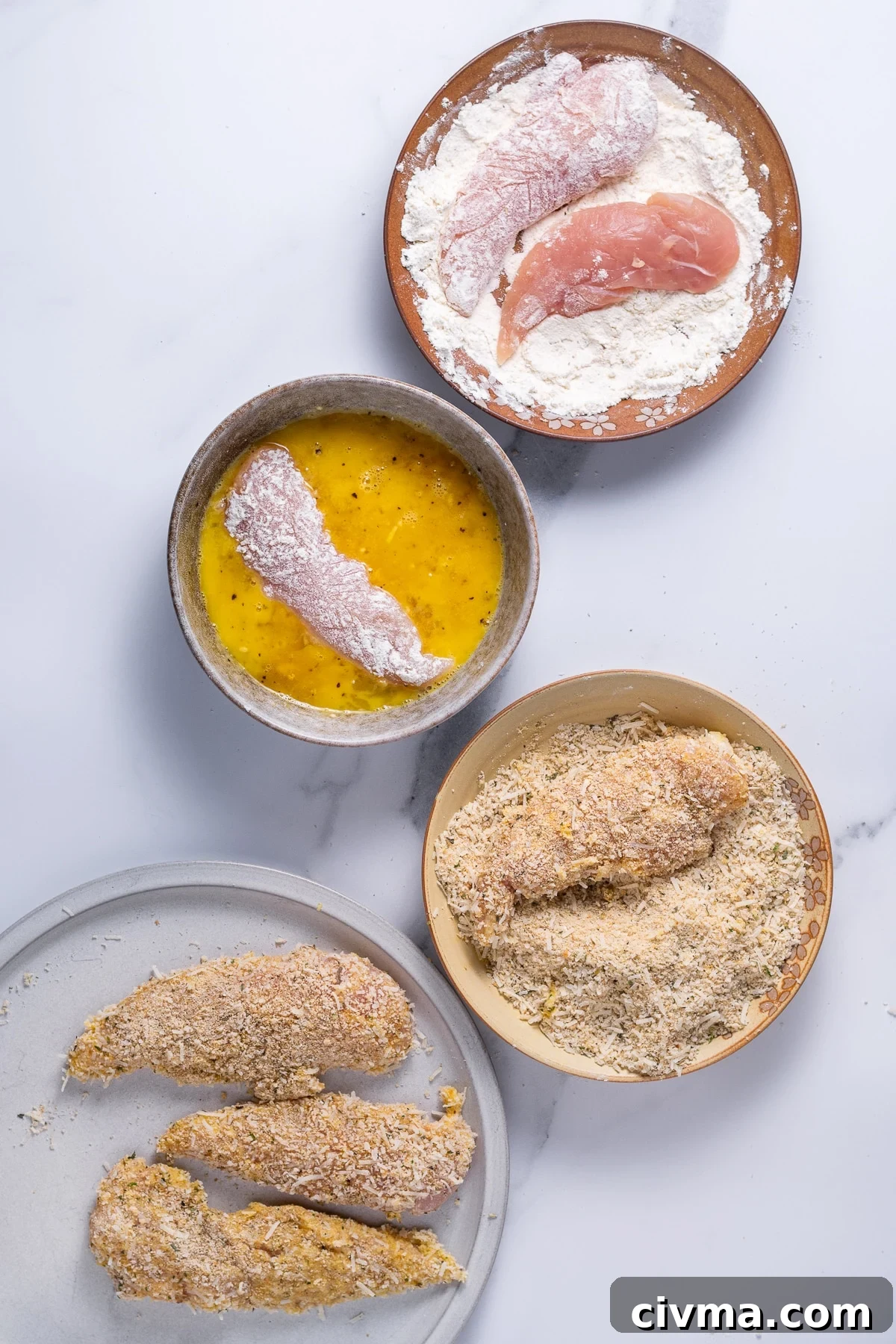 chicken tenders being coated in flour, then egg and finally parmesan breadcrumbs