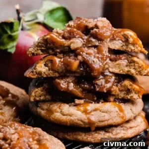 Salted Caramel Apple Pie Cookie Recipe 13 A stack of caramel apple pie cookies with a few broken in half to show the chewy cookies and apple filling.