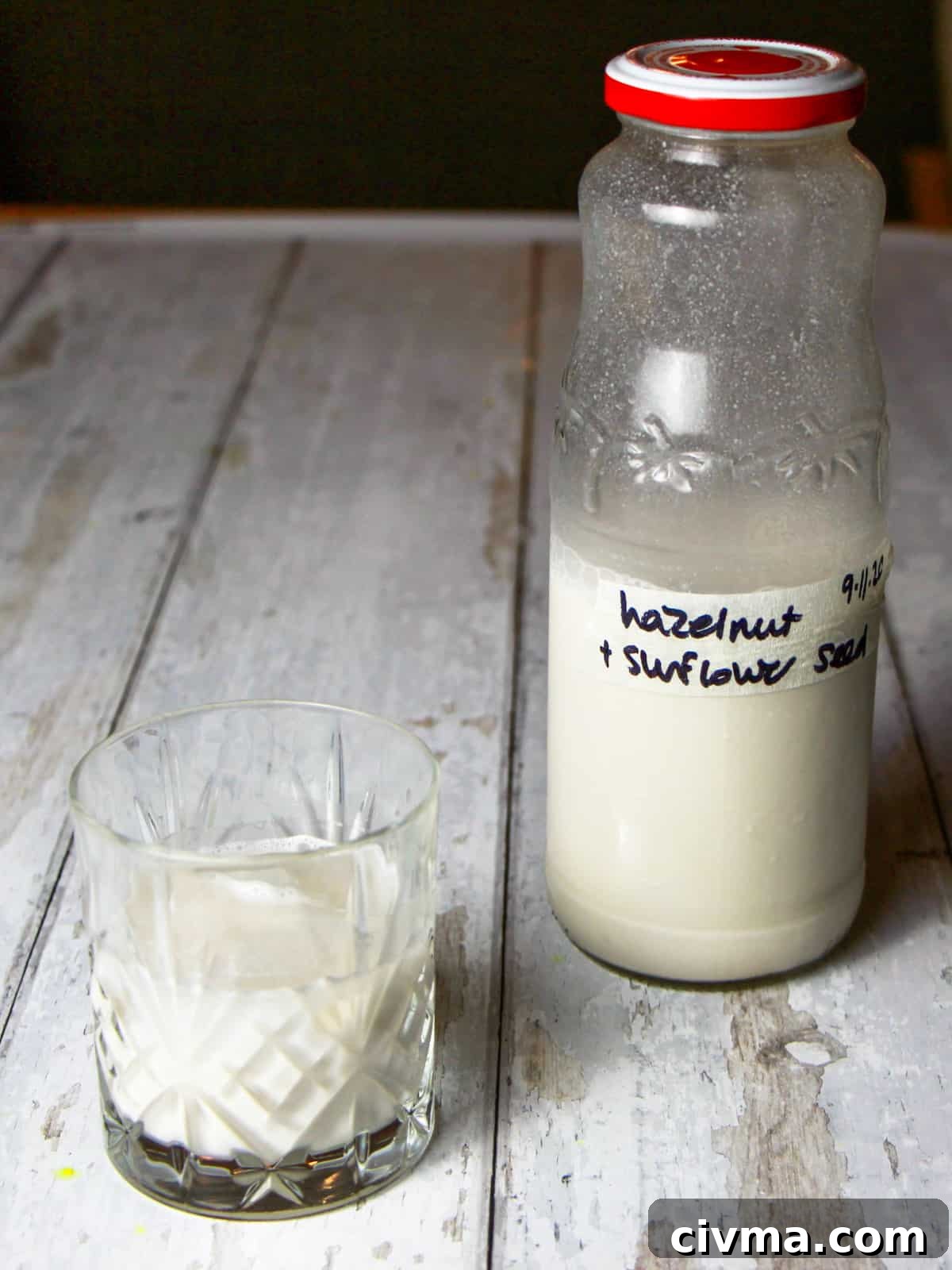 Hazelnut Sunflower Seed Milk Recipe 5 Photo of a bottle of hazelnut and sunflower seed milk with a glass full of milk next to it.