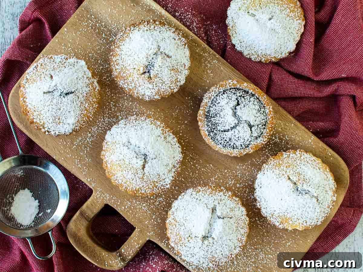 Bocconotti: Italian Chocolate-Almond Pastries from Puglia 12 Sugar dusted small pies on a wooden board viewed from above.